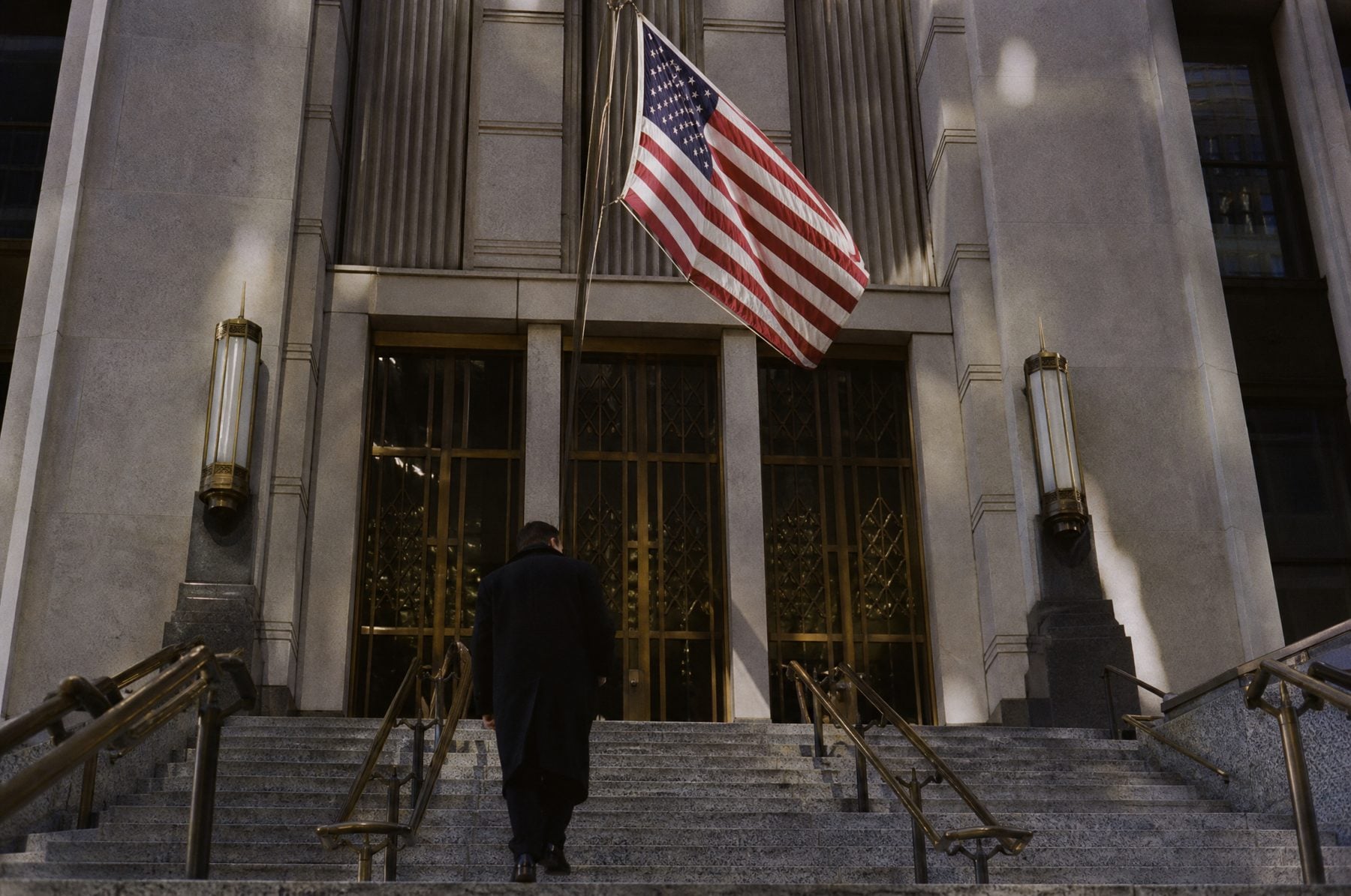 Entrance steps of a consulate beneath an American flag